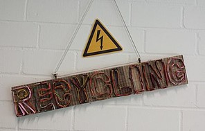Schief hängendes Holzschild mit der Aufschrift "Recycling" Schief hängendes Holzschild mit der Aufschrift "Recycling"