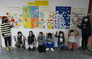 Die Energiemanager*innen Die Energiemanager*innen stehen vor ihren selbstgestalteten Plakatwänden, die ihre Klimaschutz-Projekte thematisieren.