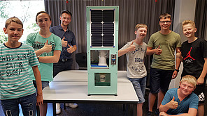 Schüler und Prototyp-Ausgabeautomat für Becher Schüler mit Prototyp-Ausgabeautomat für Becher.