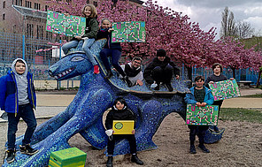 Grundschüler*innen halten ihr Brettspiel Espaspi, ein Energiesparspiel in der Hand.