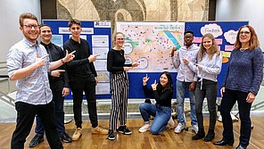 Gymnasiast*innen mit nachhaltigem Stadtplan im Hintergrund.