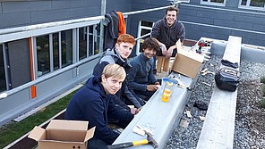 Schüler mit Lehrer auf dem Dach vom Passivhaus. Schüler mit Lehrer auf dem Dach des Passivhaus.
